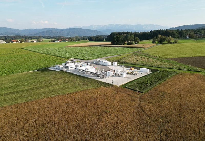 Underground Sun Storage mit grünen Feldern und blauem Himmel