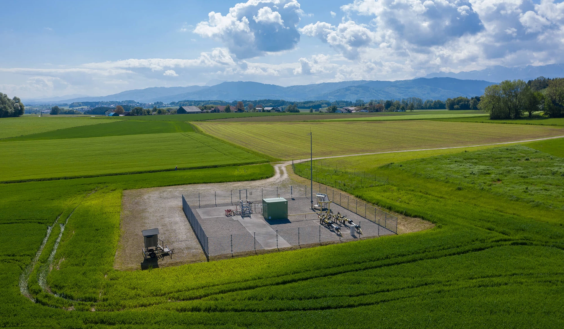Storage facility with green fields and blue sky from above
