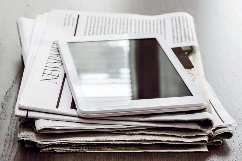 Tablet, dass auf einem Zeitungsstapel liegt